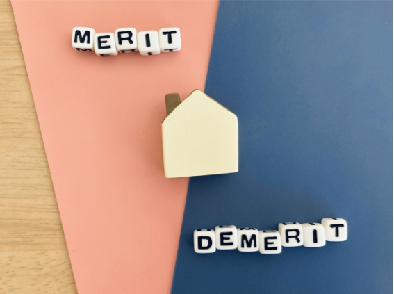 不動産クラウドファンディングのメリットとデメリットをイメージした図。家の模型とMERIT・DEMERITの文字ブロック。
