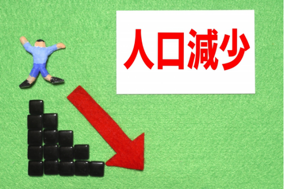 人口減少を示す赤い矢印と下がるグラフのイメージ