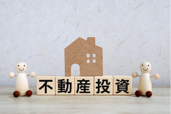 不動産投資を象徴する家の模型と文字ブロックのイメージ